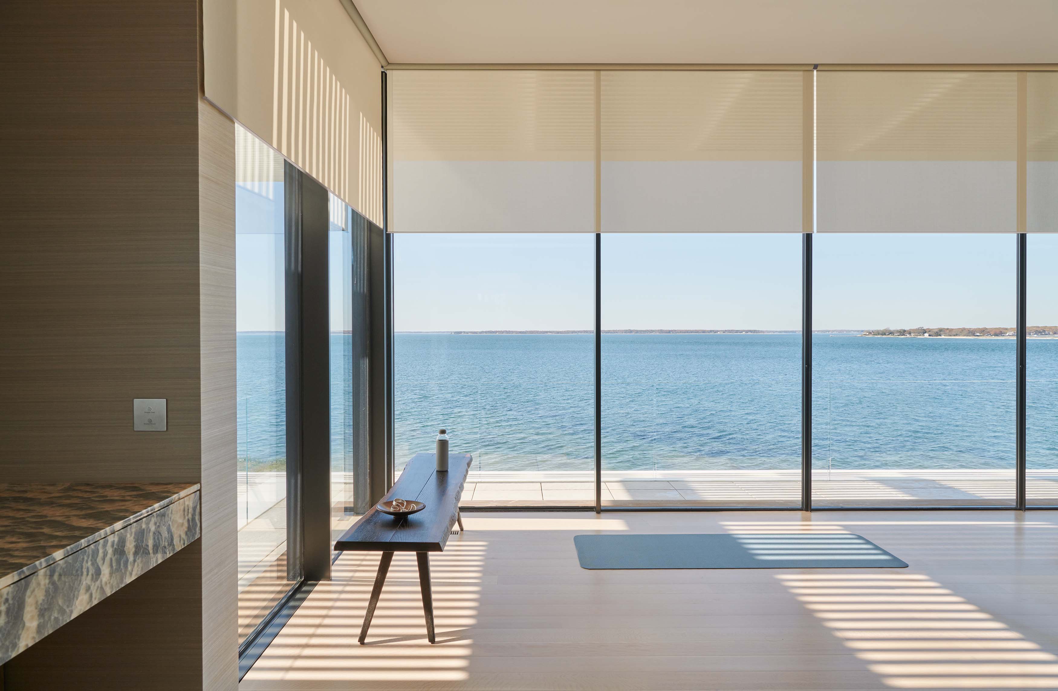 scene through a coastal window with motorized shades lowering